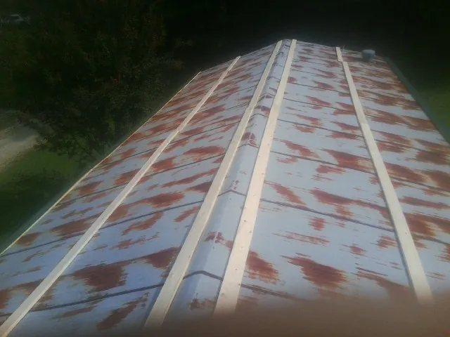 Rusted metal roof panels with new wood purlins before replacement — Storm Damage Roof Repair in Putnam Station by Roofing Brothers