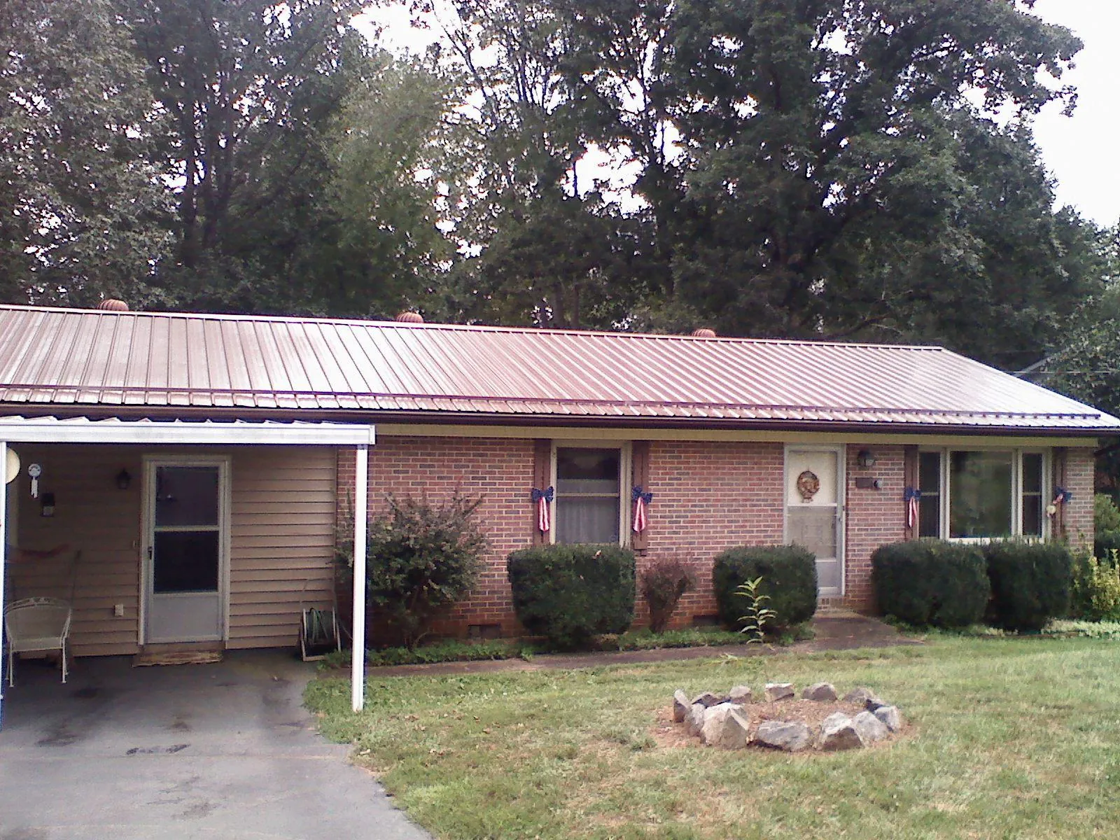 Bronze metal roof and carport on a brick ranch home — Roof Repair work by our crew in Putnam Station